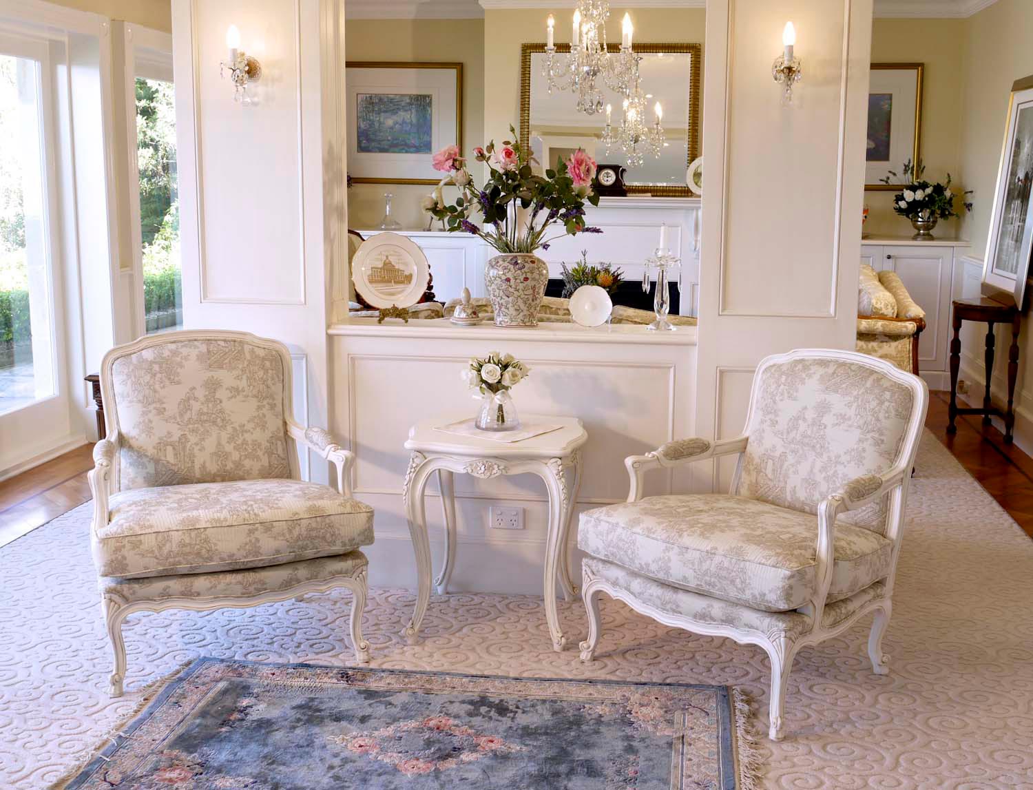 1 French bergere armchairs painted in white with side table and rug and chandelier