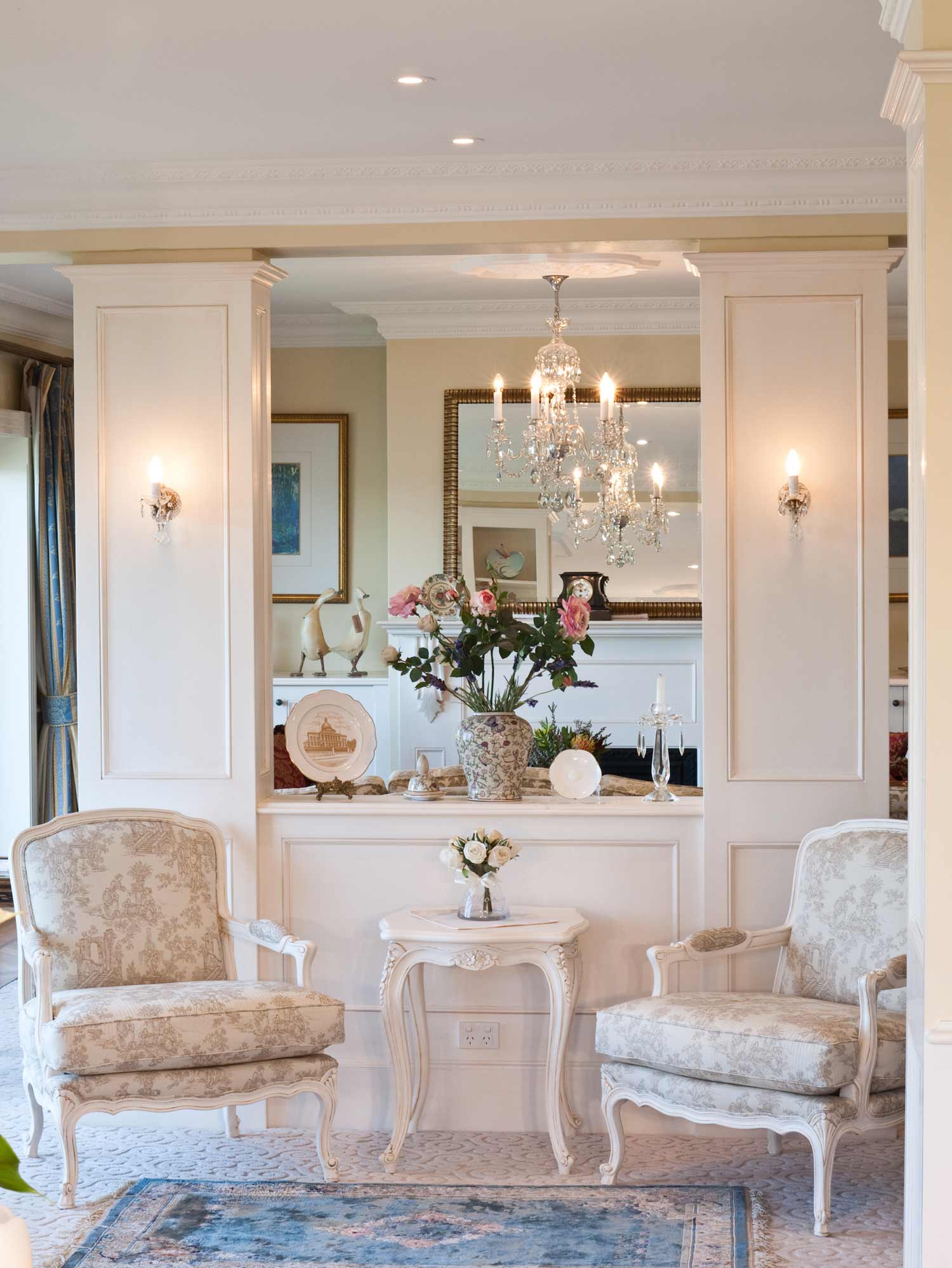 1 Wall panelling in french lounge interior with armchairs, side table and chandelier