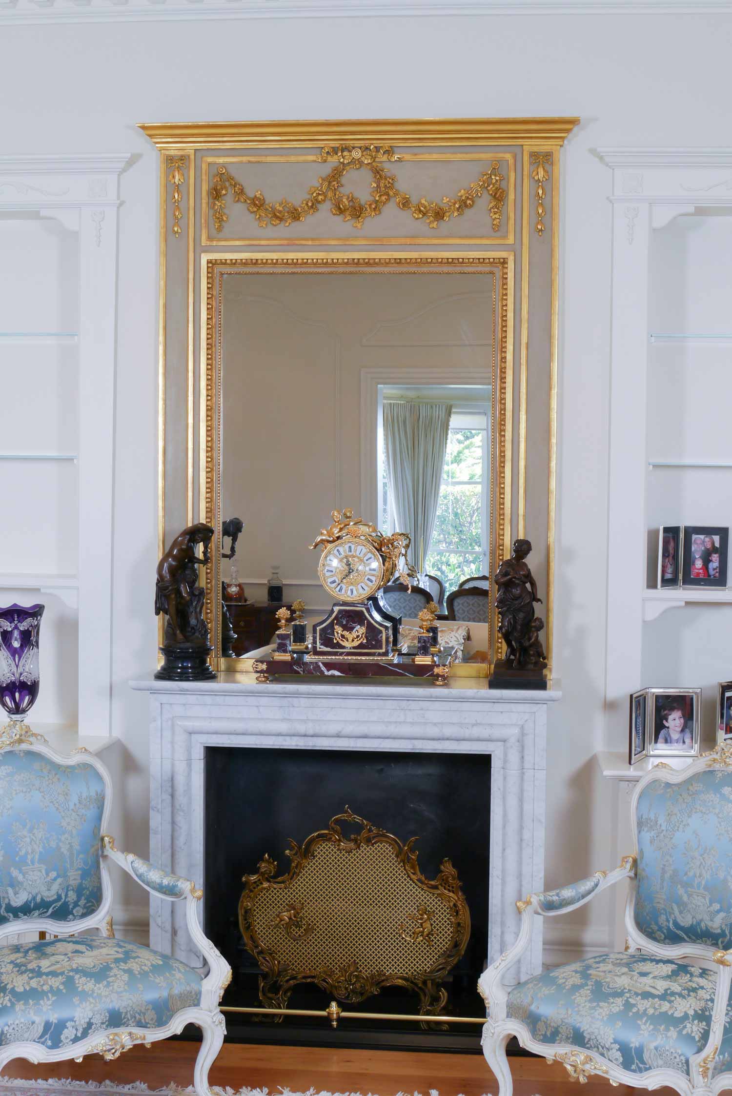 5 Lounge setting in french style interior with armchairs, mirror and décor with book case