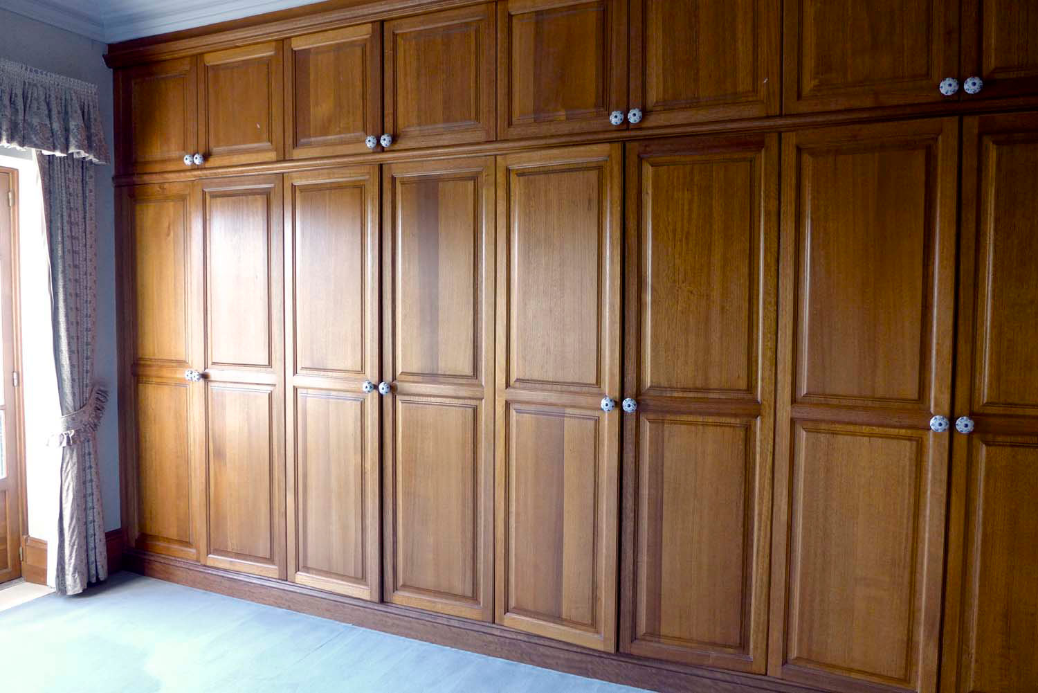 5 Timber wardrobe custom designed with panelled doors and curtains