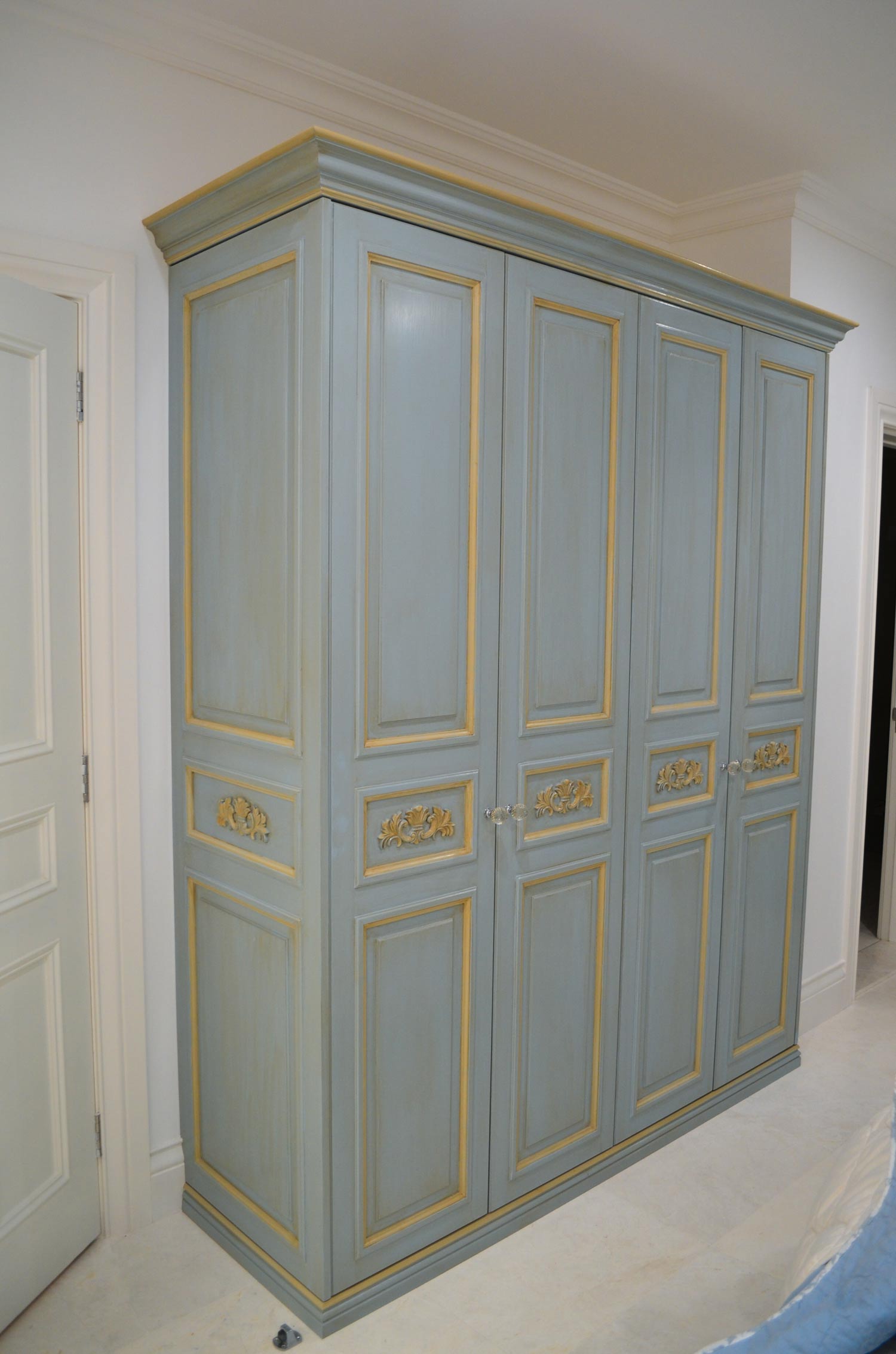 8 Custom finish on wardrobe with four doors, panelling in yellow gold