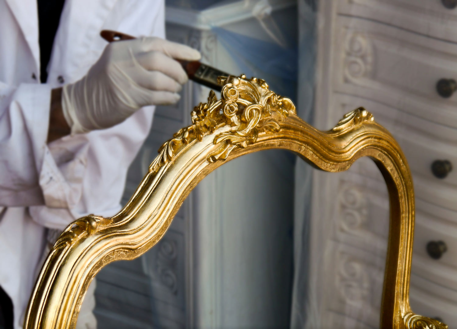 8 Our gilder finishing the gold leaf on traditional french Louis armchairs