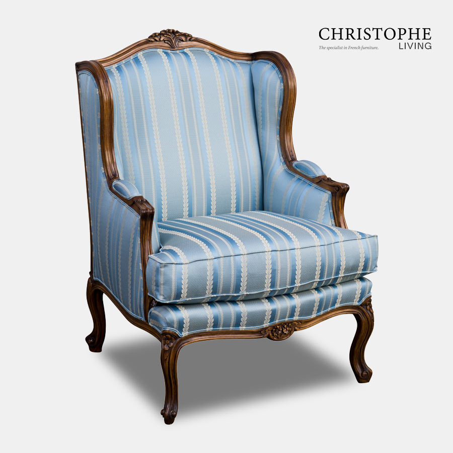 A timber armchair in French Louis style with carved timber and fabric in blue with multiple stripe ideal for loungeroom.