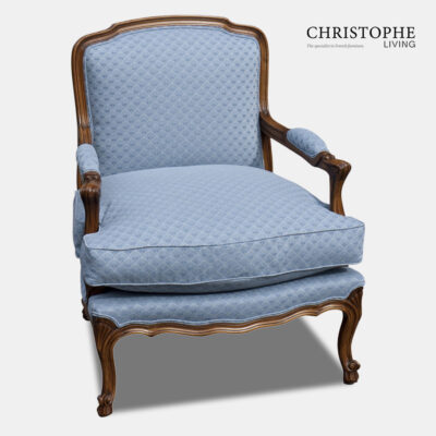 Walnut timber French provincial armchair for creating a French country loungeroom style décor. Chair is in a timber finish and upholstered in a blue fabric.