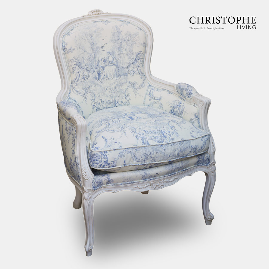 French bedroom chair in blue and white jovial fabric with cushion and curved legs painted white.