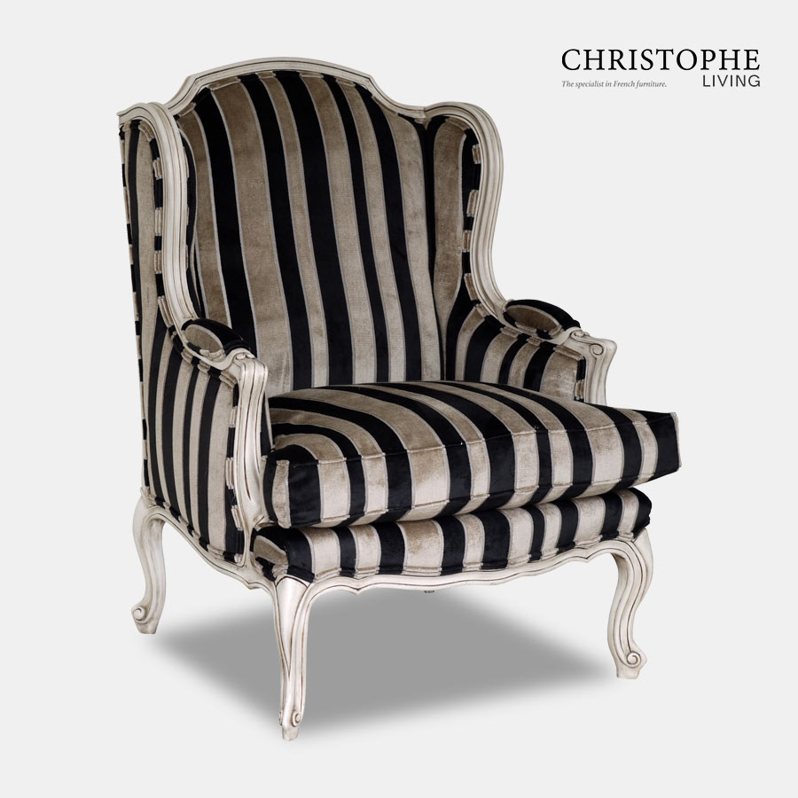 Armchair carved French provincial style with painted finish and antique patina. Upholstered in a velvet stripe with black and gold tone.